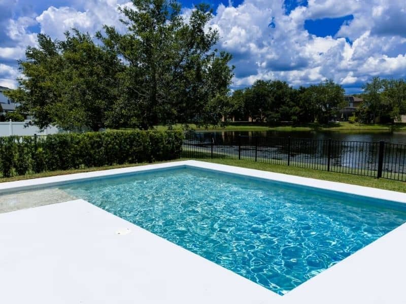 Backyard swimming pool and fenced yard with property line markers considered before installation